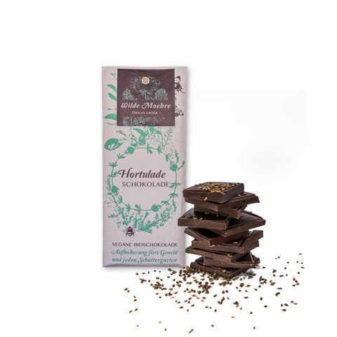 Hortulade Wilde Möhre Bio vegane Schokolade mit Schokoladenstapel daneben