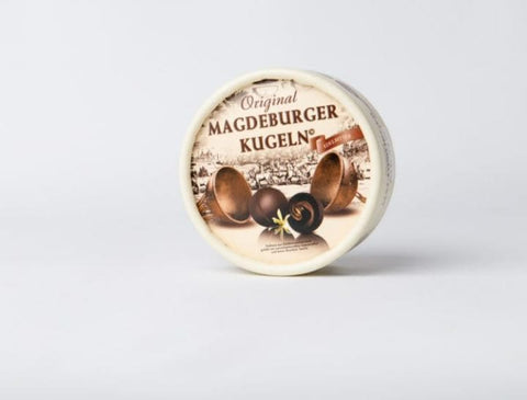 Magdeburger Kugel – Die Otto von Guericke-Metallkugel in edler Papp-Runddose  Feine Pralinen aus Edelbitterschokolade, gefüllt mit zartschmelzendem Sahnetrüffel - Hochkant freisteller