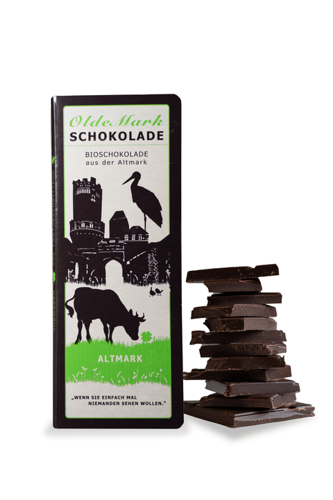 OldeMark Bio vegane Schokolade mit 50% Kakaoanteil und Haselnussmus Einzeltafel mit Schokoladenstapel daneben