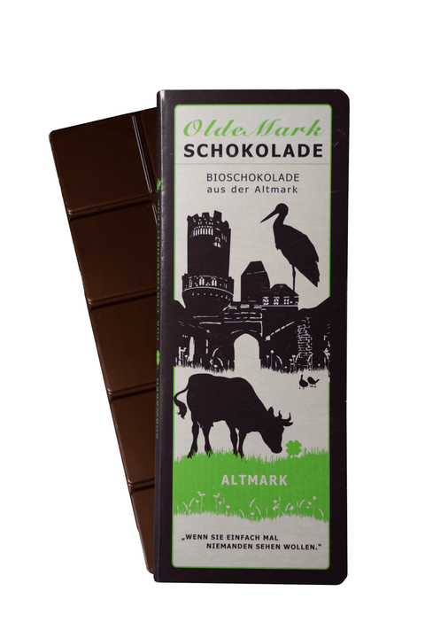 OldeMark Bio vegane Schokolade mit 50% Kakaoanteil und Haselnussmus mit offener Schokoladentafel dahinter